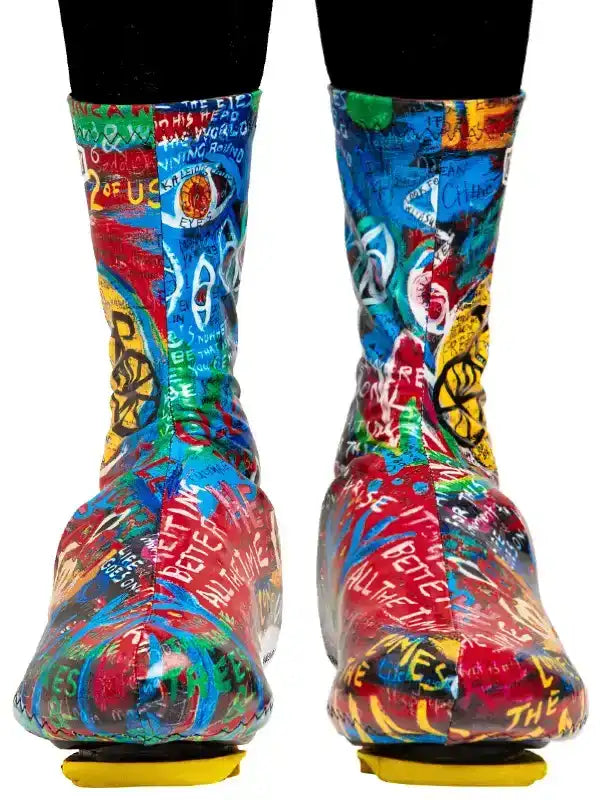 Colorful graffiti-style cycling shoe covers with bold text and graphics for road bike riders