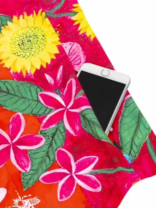 Vibrant floral cycling jersey pocket holding smartphone, featuring sunflower and plumeria print on performance fabric