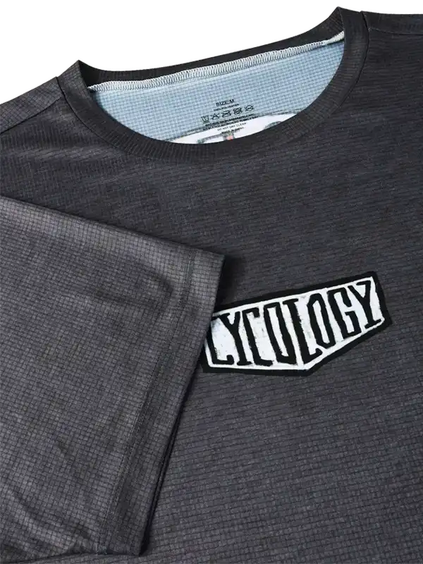 Men's dark gray cycling jersey with 'CYCOLOGY' chest patch, waffle-textured fabric, ideal for performance rides.