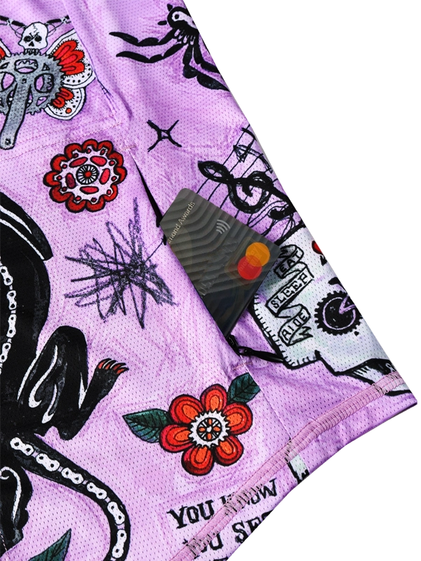 Close-up of a purple fabric with black and white tattoo-style designs, including flowers and text zipper