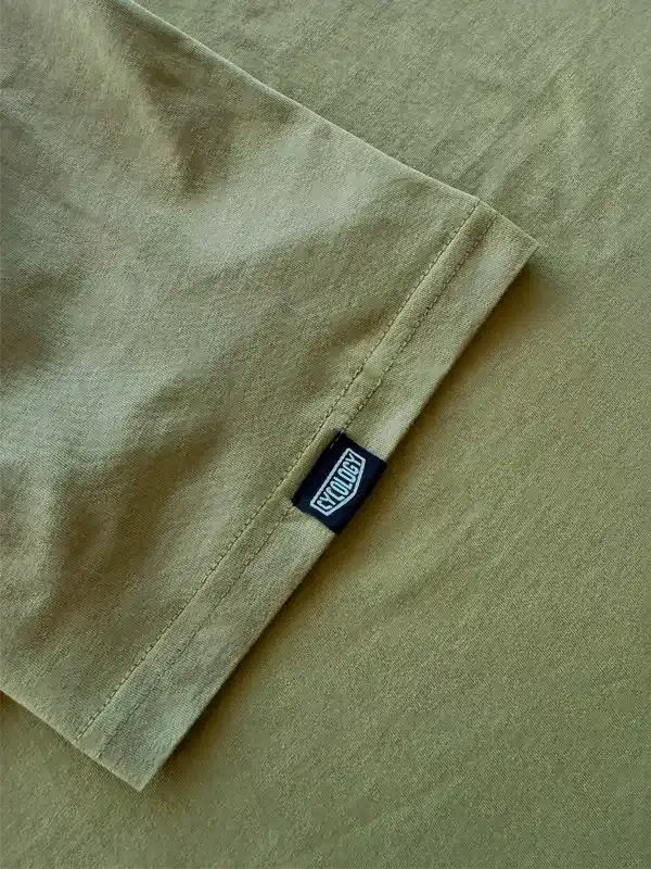 Olive green cycling jersey sleeve with black Cycology brand tag, showcasing quality fabric and stitching detail.