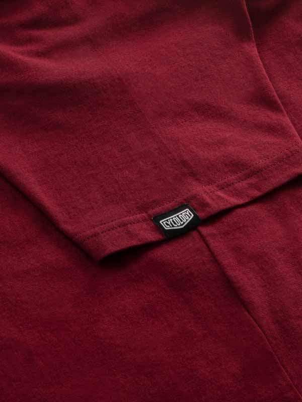 Close-up of maroon cycling jersey with brand tag, showcasing soft fabric texture for men's and women's rides