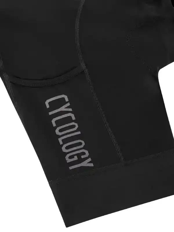 Black cycling shorts with 'CYCOLOGY' logo, featuring padded design for comfort during rides.