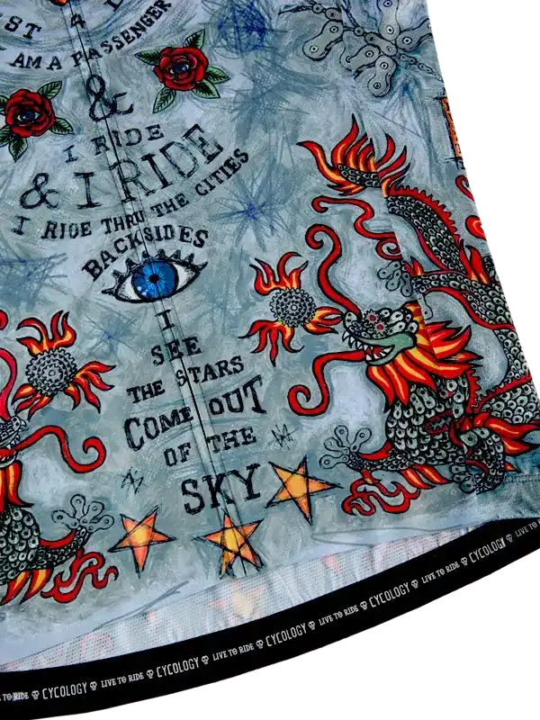 Cycling jersey with dragon, roses, stars, and bold text design on light blue fabric