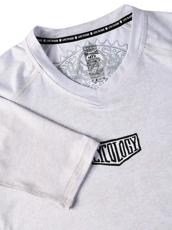 Day of The Shred Grey Women's Long Sleeve MTB Jersey Close-up with a logo on the chest and a V neck.