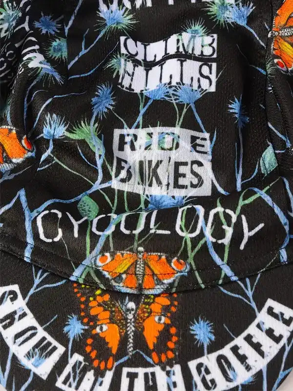 Cycling jersey with 'Climb Hills Ride Bikes' text, butterflies, and floral print on black fabric