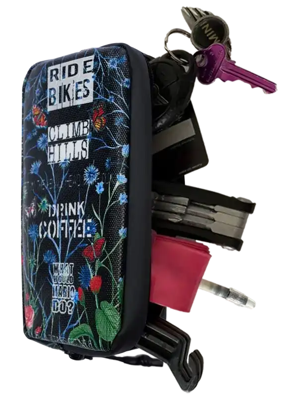 Floral cycling key organizer with 'Ride Bikes Climb Hills Drink Coffee' text, holding keys and tools