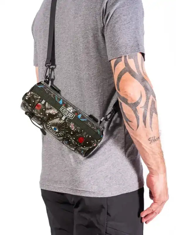 Person wearing a crossbody handlebar bag with colorful designs and 'Cycology' branding