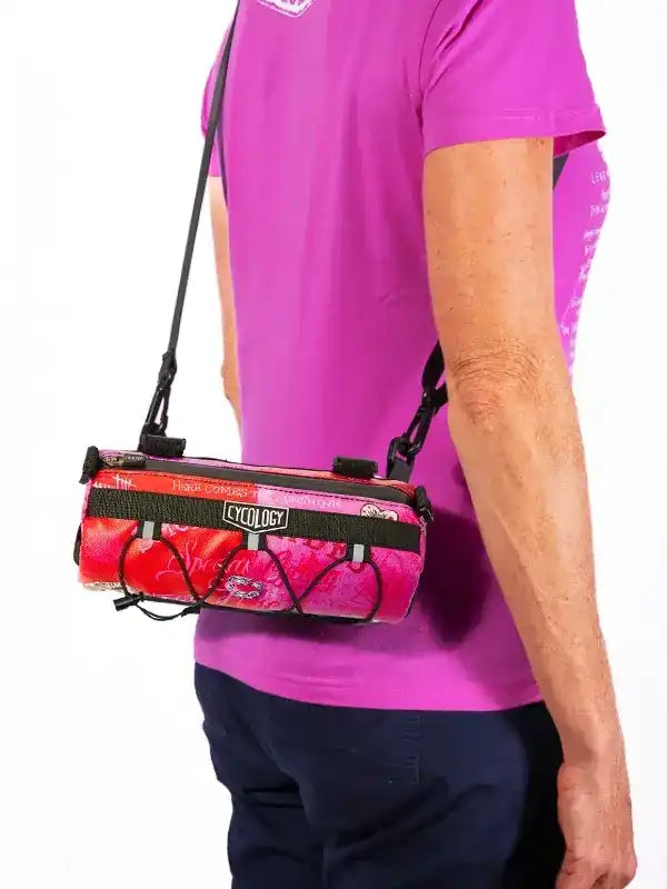 Cycling bag with vibrant pink design, worn crossbody by cyclist in matching jersey