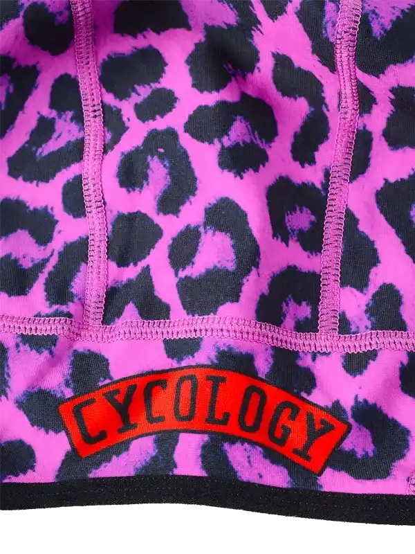 Pink leopard print cycling jersey with bold 'CYCOLOGY' logo, featuring high-quality fabric and vibrant design.
