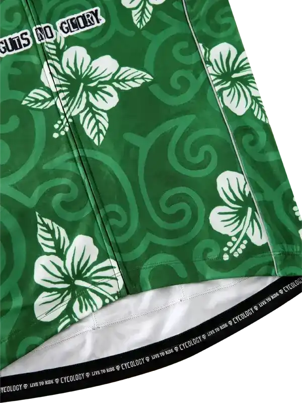 Green cycling shorts with white hibiscus flowers and swirl patterns, featuring 'GUTS NO GLORY' text and branded waistband.