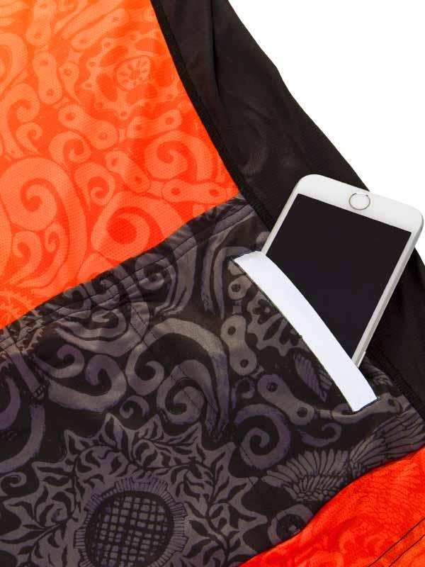 Cycling jersey pocket holding smartphone, orange and black patterned design, functional storage for rides
