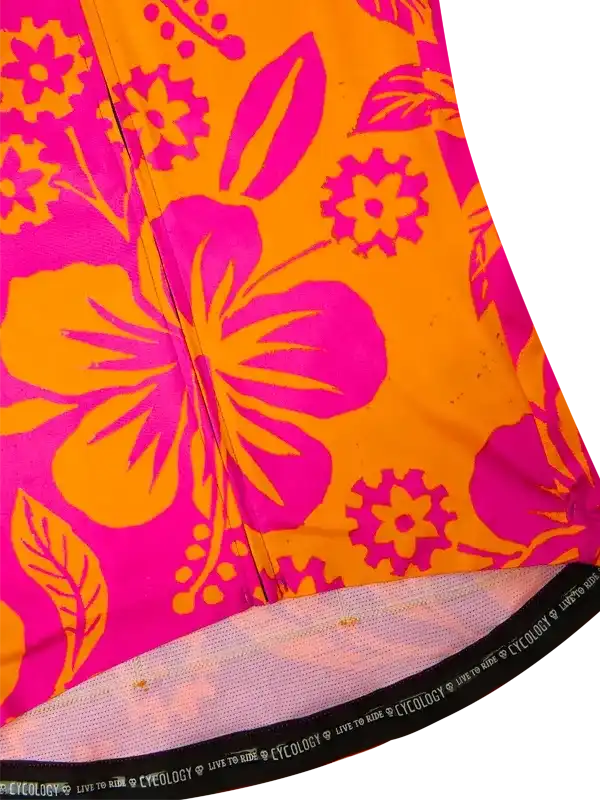 Vibrant pink and orange floral cycling jersey with bold hibiscus print and 'Live to Ride' hem detail