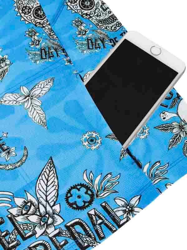 Blue cycling jersey pocket holding phone, floral and gear print design
