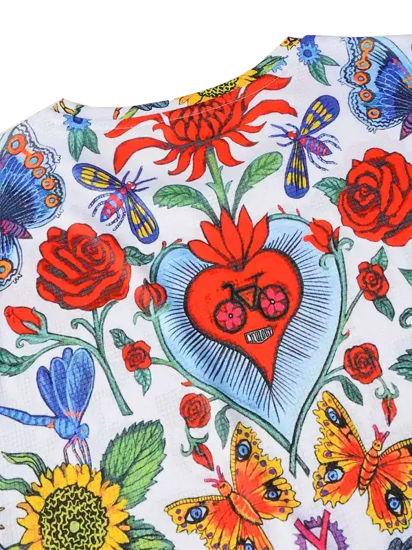 Vibrant floral cycling jersey with heart, butterflies, and bike graphic on white fabric