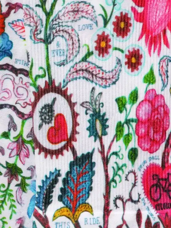 Colorful floral cycling apparel print with hearts, leaves, and bike motifs on white fabric