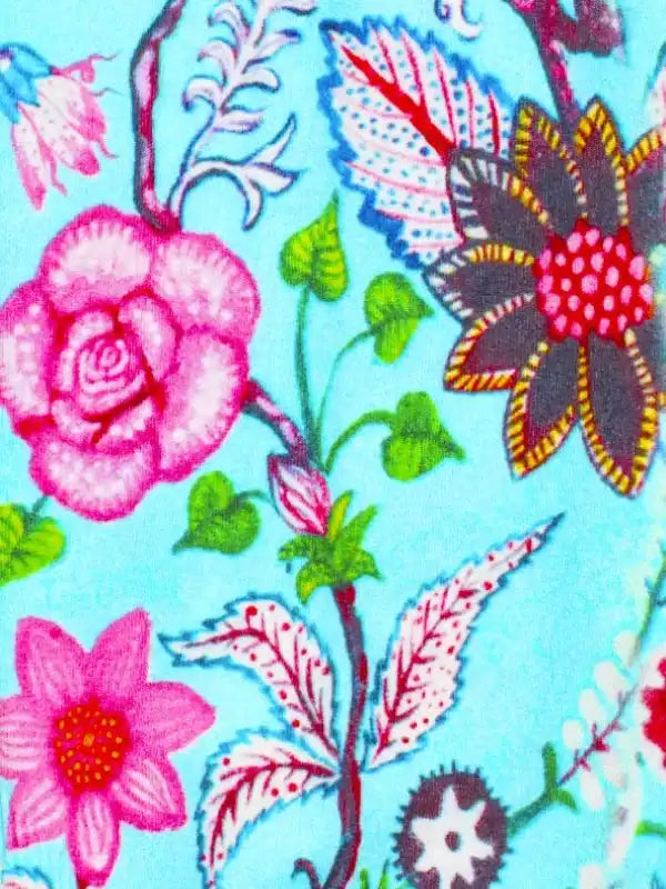 Vibrant floral pattern on cycling apparel fabric with pink roses, green leaves, and blue background