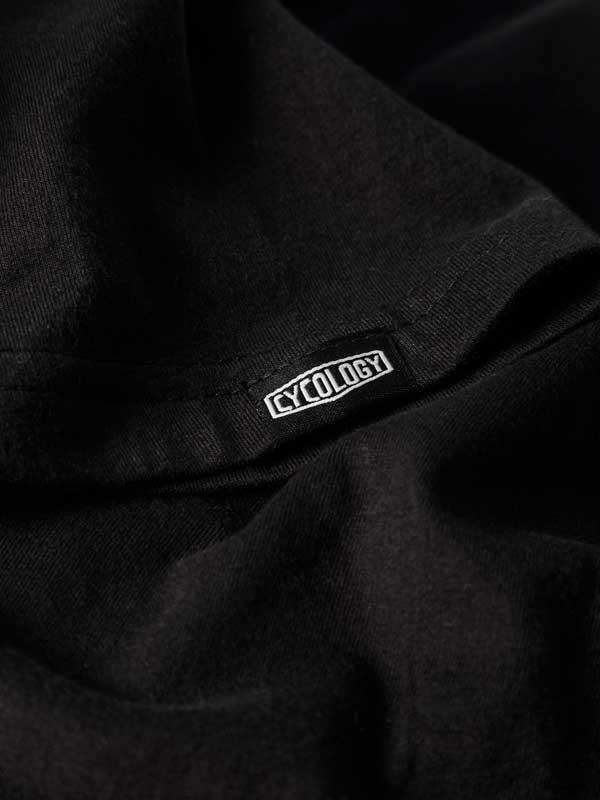 Black cycling apparel with white Cycology logo tag, high-quality fabric detail