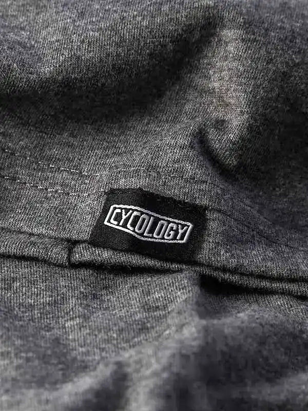 Close-up of Cycology brand tag on dark gray cycling apparel fabric