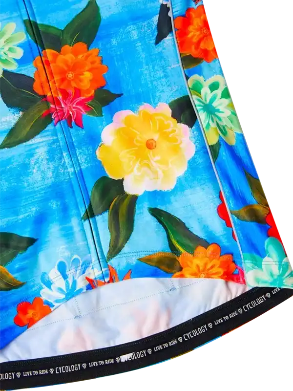 Vibrant floral cycling jersey with bold orange, yellow, and blue flowers on blue background, featuring 'LIVE TO RIDE' hem detail