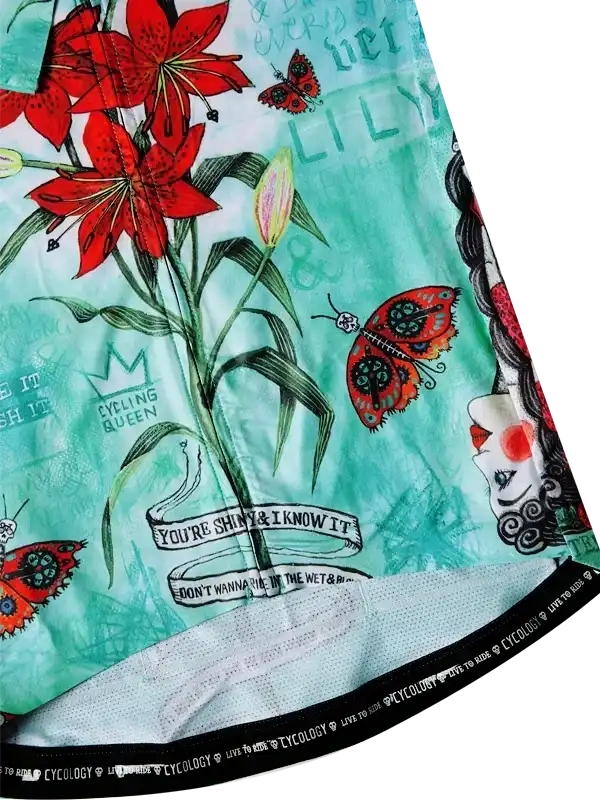 Cycling jersey with red lilies, butterflies, and 'Cycling Queen' text on teal fabric
