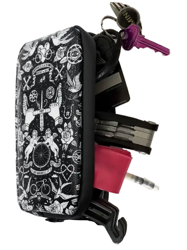 Black and white tattoo-style cycling key case with keys, multitool, and pink accessory
