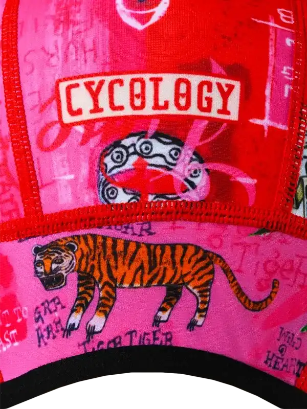Vibrant pink and red cycling cap with bold tiger graphic and 'CYCOLOGY' logo, perfect for bike rides.