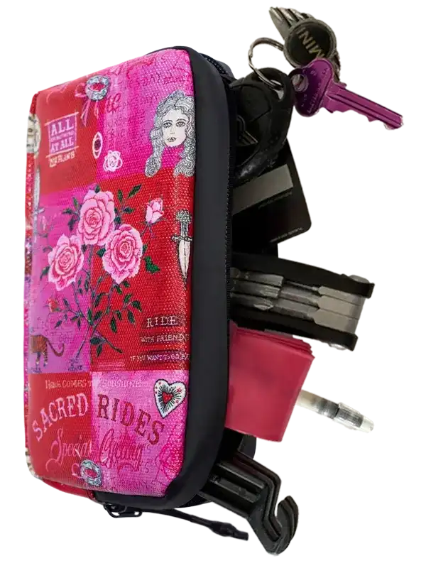 Pink floral cycling accessory pouch with keys, multi-tool, and tire lever, featuring 'Sacred Rides' design