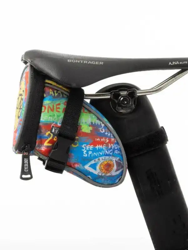 Colorful graffiti-style cycling saddle bag attached to Bontrager seat, ideal for bike rides and storage.