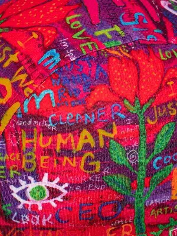 Vibrant cycling jersey with bold 'HUMAN BEING' print, colorful graffiti art, and floral design for men and women.