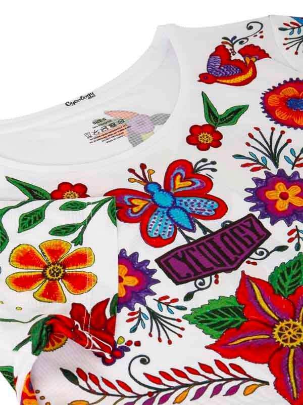 White cycling jersey with vibrant floral and butterfly print, featuring colorful embroidery and 'CYCLOGY' logo.