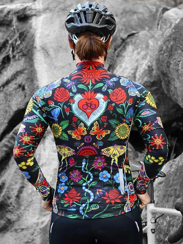 Colorful floral cycling jersey with heart design, worn by cyclist in rocky outdoor setting