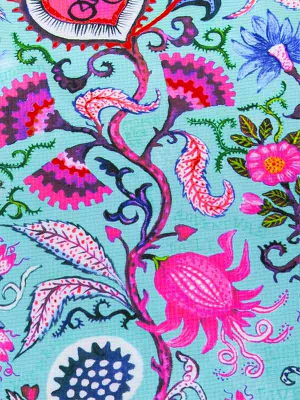 Vibrant floral cycling apparel fabric with pink, blue, and green botanical print on teal background