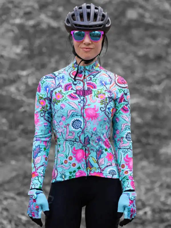 Woman in vibrant floral cycling jersey, helmet, and sunglasses, ready for a ride