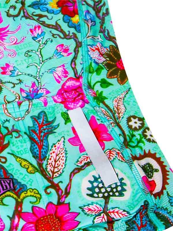 Vibrant floral cycling shorts with bold pink, blue, and green botanical print and reflective strip