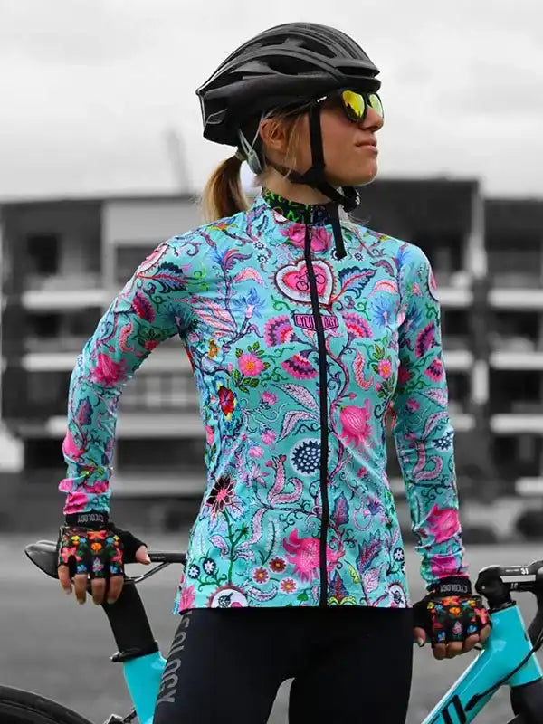 Woman in vibrant floral cycling jersey, helmet, and gloves, ready for a ride