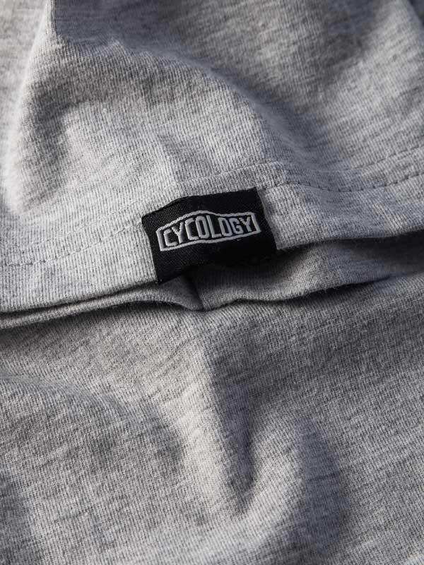 Grey cycling apparel with black Cycology brand tag, showcasing high-quality fabric detail