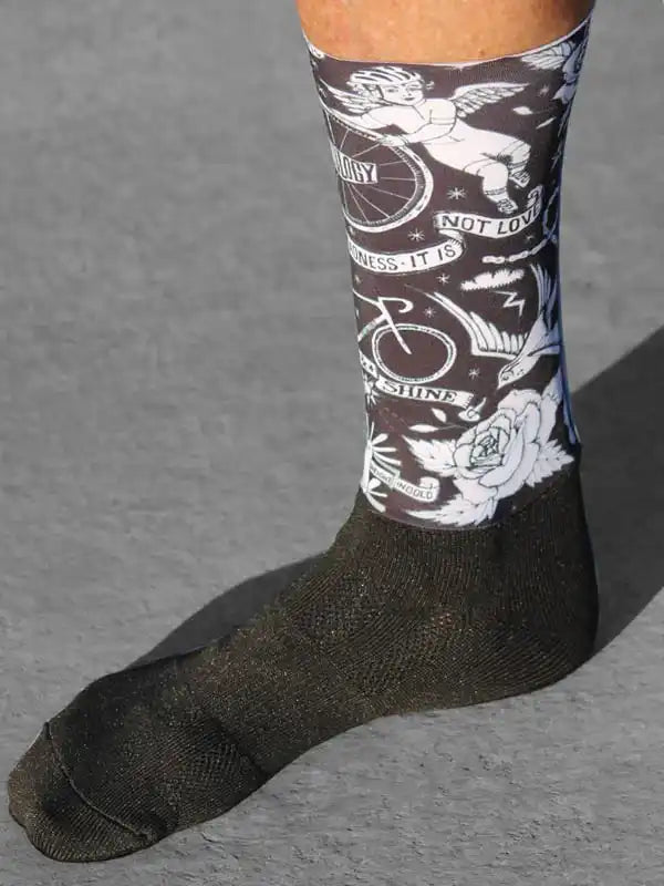 Cycling sock with angel, bike, and rose tattoo-style design on dark background