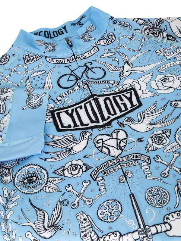 Light blue cycling jersey with tattoo-style graphics, birds, roses, and 'Cycology' logo for men's and women's bike wear.