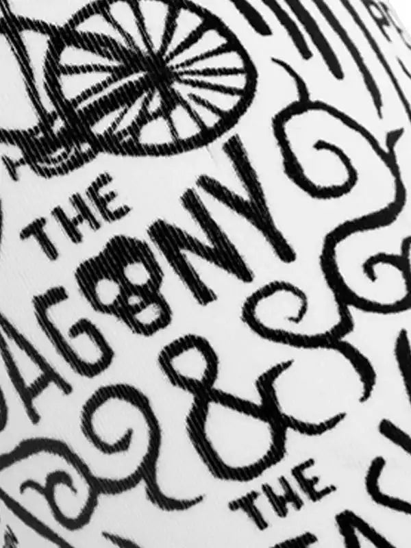 Close-up of cycling apparel with bold 'THE AGONY & THE ECSTASY' graphic print and vintage wheel design