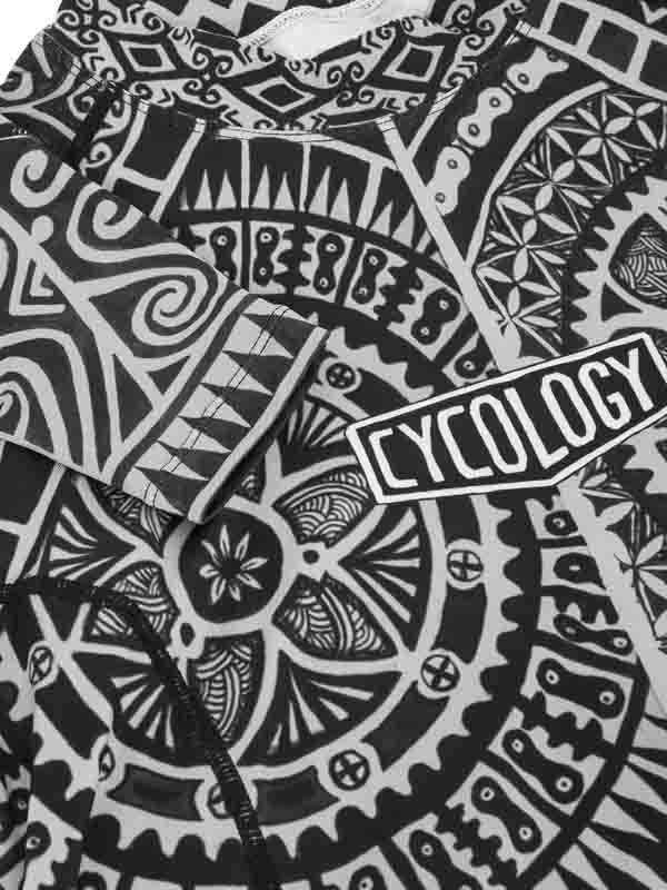 Black and white patterned cycling jersey with 'CYCOLOGY' logo, featuring bold tribal designs for men's and women's bike wear.