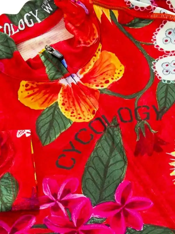 Vibrant red cycling jersey with tropical floral print and 'CYCOLOGY' branding, featuring zipper and high-quality fabric details.