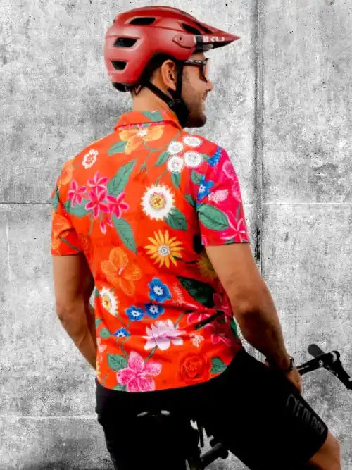 Man in vibrant floral cycling jersey and red helmet, ready to ride
