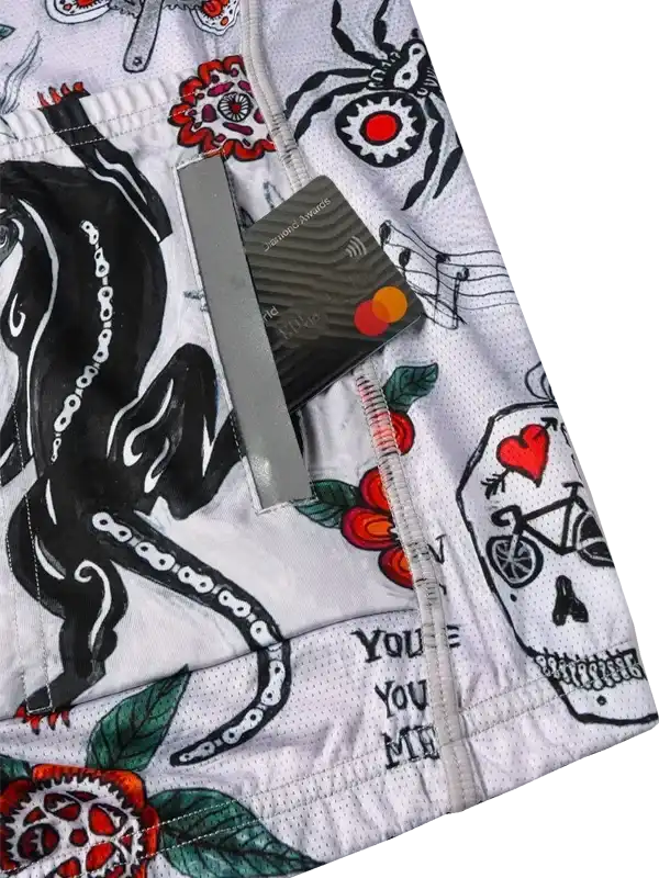 Men's cycling shorts with bold tattoo-style graphics, skull, octopus, and floral designs on white fabric