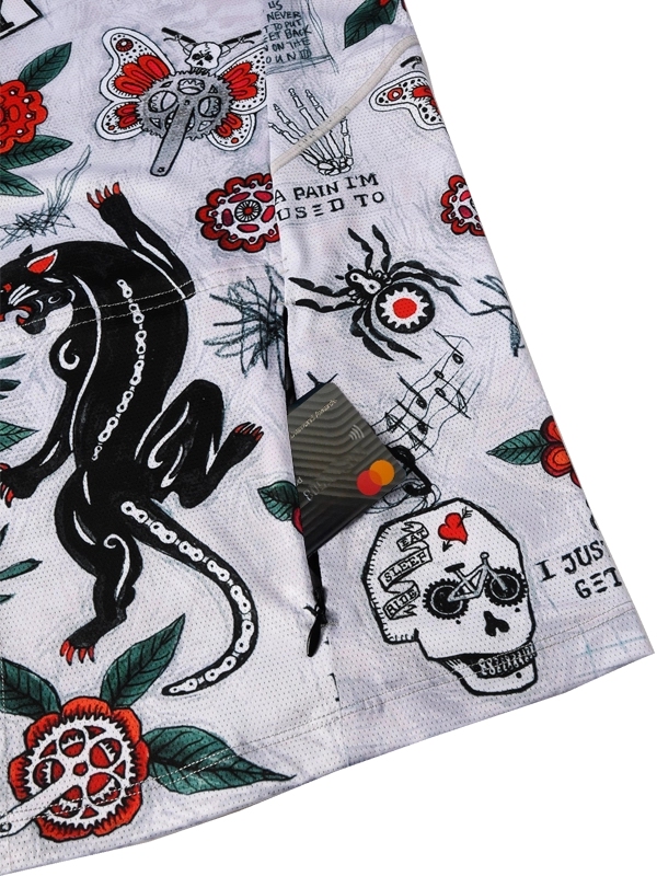 Close-up of a zipper pocket  and fabric with tattoo-style designs including a panther, skull, and text on a grey  background.