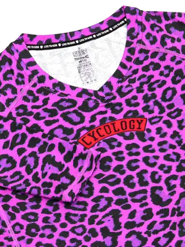 Vibrant pink leopard print cycling jersey with red Cycology logo, ideal for women's bike wear.