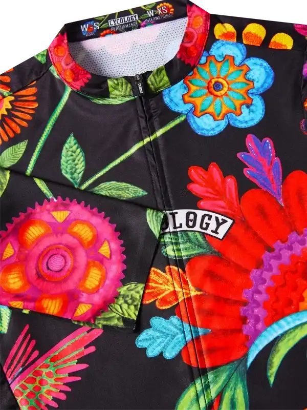 Vibrant floral women's cycling jersey with bold colors and 'OLOGY' logo, perfect for road biking.