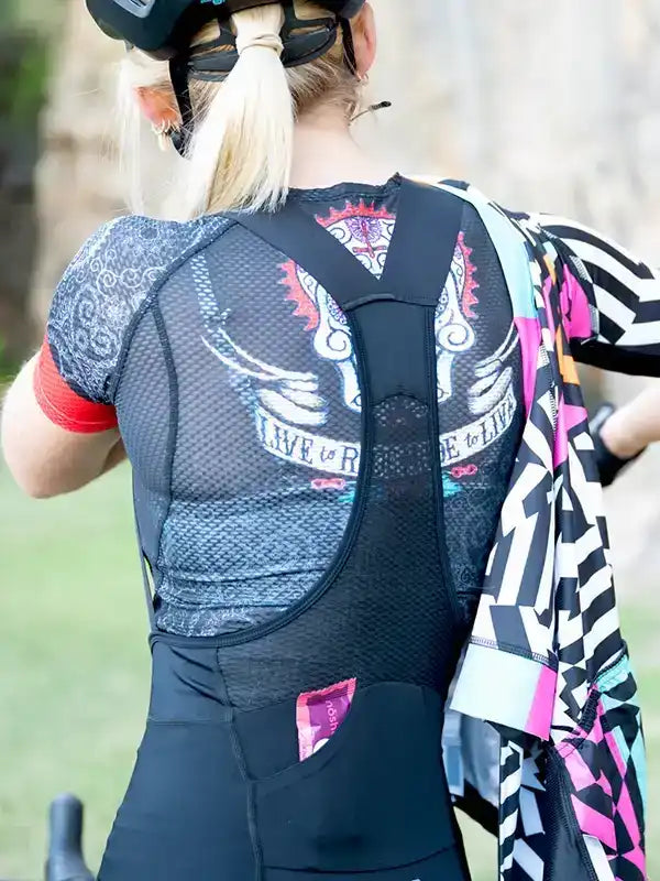 Woman in cycling jersey with 'Live to Ride' graphic, mesh back, and colorful patterned sleeves