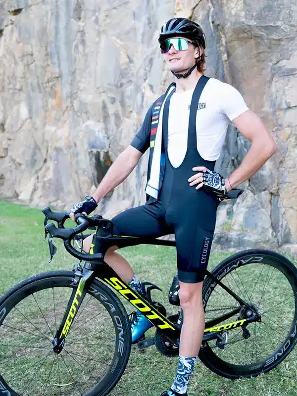 Man in cycling bib shorts and jersey posing with Scott road bike outdoors