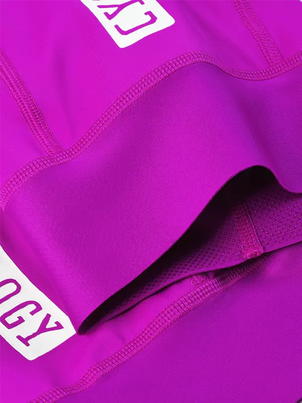 Close-up of a bright magenta cycling bibs showing the fabric texture, grip inside leg cuff 